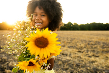 Pretty afro american young girl in a sunflowers field