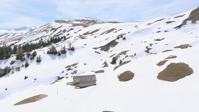 Einzelne Almh&uuml;tte in den schweizer Bergen im Fr&uuml;hling bei Schnee