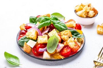 Fresh summer salad with tomatoes, stale bread, onion, cheese, green basil and olive oil, white table background, top view - 790156139