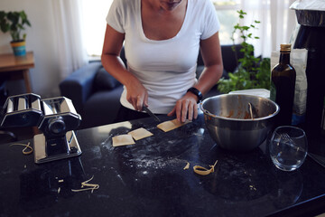 Hands, home and knife on pasta for baking food, meal prep and healthy lunch for nutrition in...
