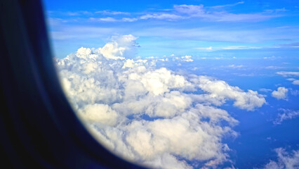 Bright blue sky with clouds, view from airplane window. Sky and clouds background. Natural nature...