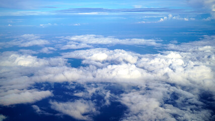 The earth and sky aerial view from the airplane. Blue sky and clouds. Blue summer sky with white clouds vibrant color background. Sky cloud natural backgrounds.