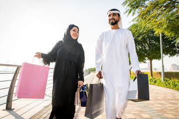 Arabic couple wearing kandura and abaya shopping in Dubai