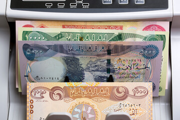 Iraqi Dinar in a counting machine - obrazy, fototapety, plakaty