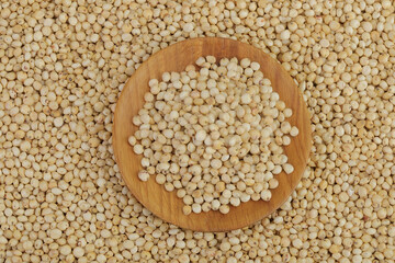 background of sorghum seeds with wooden bowl. Top view. Flat lay.