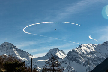 Curved Chemtrail above snowy mountains Swiss Alps Switzerland - obrazy, fototapety, plakaty