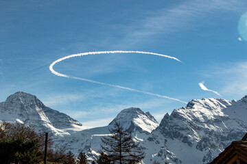 Curved Chemtrail above snowy mountains Swiss Alps Switzerland - obrazy, fototapety, plakaty