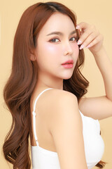 Beautiful young Asian woman model long hair with natural makeup on face clean fresh skin on isolated beige background. Cute girl portrait, Facial treatment, Body care, Beauty and Spa.