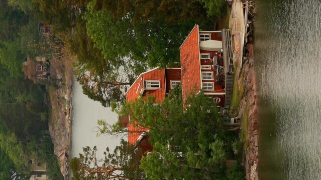 Red Swedish Wooden Sauna Logs Cabins Houses On Island Coast In Summer Cloudy Day. Vertical Footage Video.