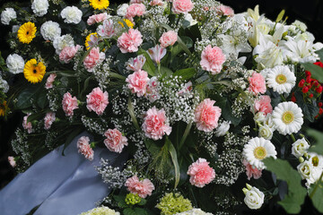 Obraz na płótnie Canvas Tag der Trauer, mit verschiedenen Blumen im Bokeh am Grab