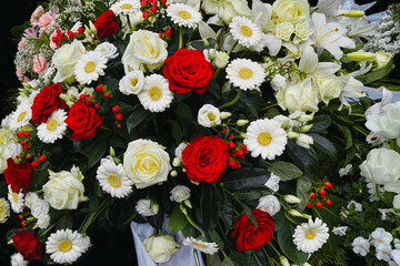 Tag der Trauer, mit verschiedenen Blumen im Bokeh am Grab