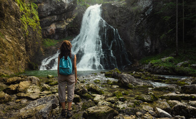 A woman standing at the Gollinger Waterfall in Torren, a district of Golling. - obrazy, fototapety, plakaty