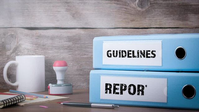 GUIDELINES REPORTS. Binders on wooden desk in the office. Business background