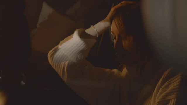 Close up of a vulnerable woman in the car being lonely, scared by thunderstorm, feeling uncomfortable. Light flashes outside, night scene. Hoping and waiting. High Quality 4k footage