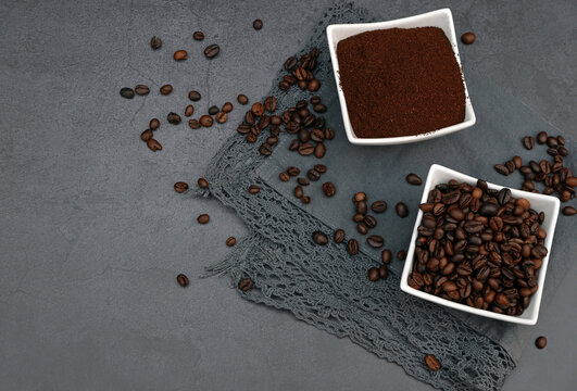Kaffeepulver mit ger&ouml;steten Kaffeebohnen auf dunklem Hintergrund mit Platz f&uuml;r Text.	