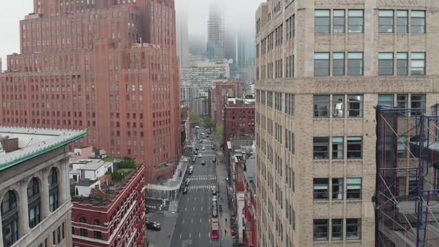 Aerial view of Hudson street in NYC. Facing south, drone descends on a misty day in Tribeca. Franklin street intersection.