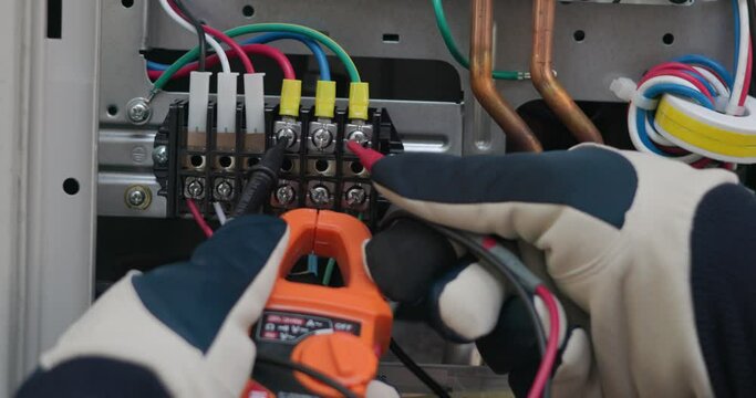 Air conditioner technician hand check condenser circuit by amp clamp meter,Air conditioner maintenance service, Home service concept