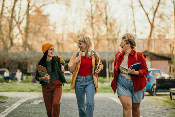 Young student women walking outdoors after classes