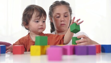 Obraz na płótnie Canvas child baby group playing cubes close-up. education a children development of fine motor skills concept. child baby group close-up hands lifestyle plays with blocks develops fine motor skills