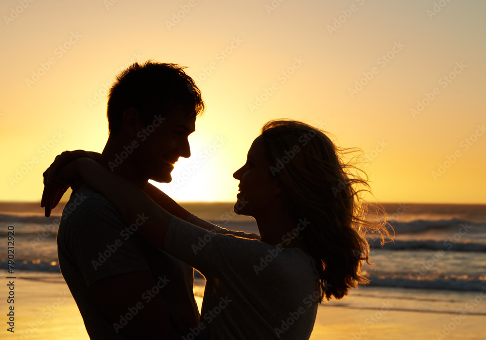 Wall mural Couple, love and smile at beach with sunset for date or summer holiday and bonding in Florida. Relationship, silhouette and romance together as soulmate with travel, hug and vacation for honeymoon