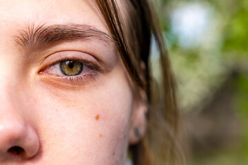 Girl without makeup, green eyes. Bright light, small pupil.