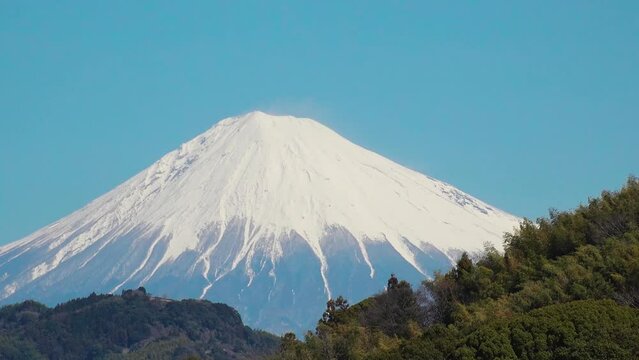SHIZUOKA, JAPAN - MARCH 2024 : Close up time lapse shot of Mount Fuji with snow on top. Tallest Mountain in Japan. Shot in spring season, sunny daytime. Japanese nature concept video.