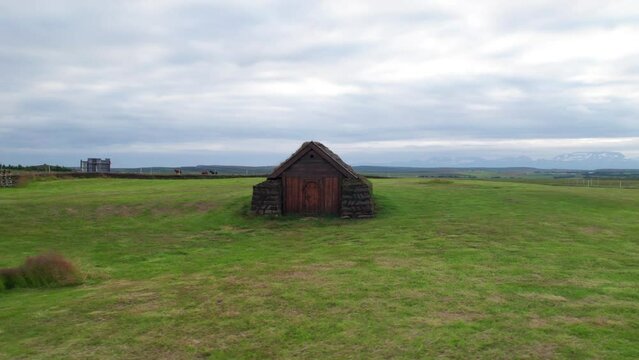 Drone Around Turf House Iceland. Low Aerial View Around Geirsstadakirkja Hut Green Grass Clouds.