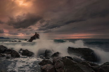 Sunset with cloudy and dramatic sky over the coast of the Cantabrian Sea on Meñakoz beach in...