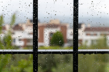 Raindrops on the glass of a barred window