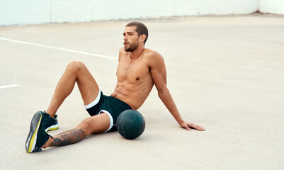 Fitness, man and medicine ball in rest for sports, exercise and health in outdoor with resting or...