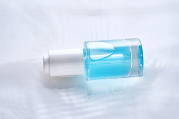 Bottles of serum with a dropper in liquid with pearl tints.