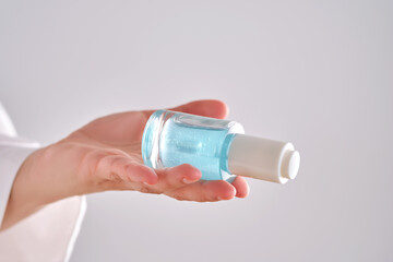 Blue serum with pipette in a womans hands in a robe.