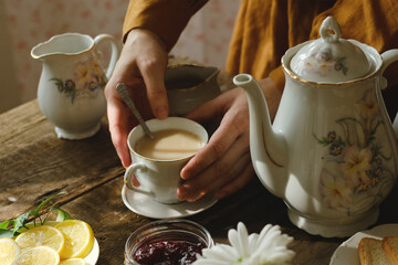 Tea party. Woman drinking tea with milk. Morning breakfast.