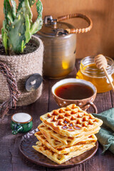 Belgian waffles served with honey, cream and sai on a wooden background. Rustic style. - 790233754