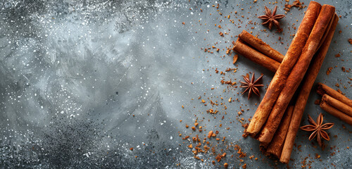Cinnamon sticks and star anise on dark textured surface. - obrazy, fototapety, plakaty