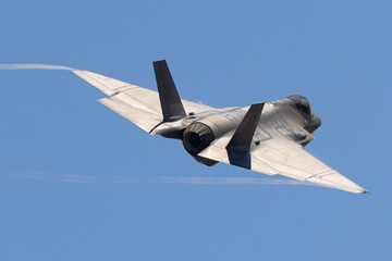 Fototapeta na wymiar Tail view of a F-35C Lightning II with trails at the wing tips 