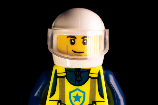 Face of LEGO police officer in white helmet and blue uniform with yellow vest