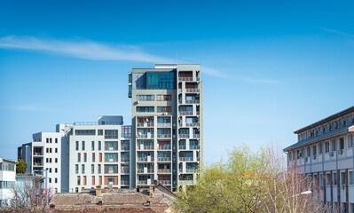 High-rise building with many apartments and a blue sky background. Multistoried modern, new and...