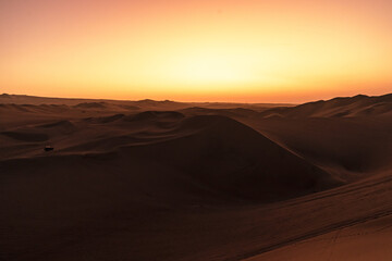 sunset over the dunes around huacachina in the Peruvian desert