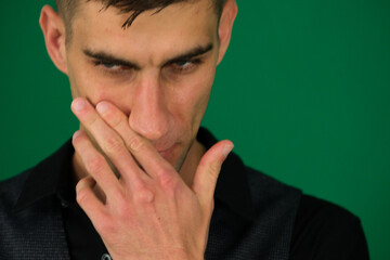 Afraid young guy in yellow T-shirt looking through fingers, white isolated background. Scared face...