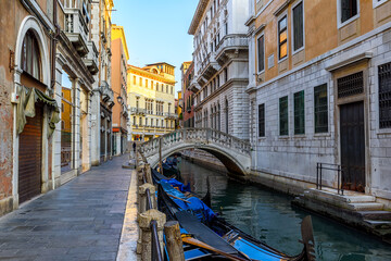 Narrow canal with gondola and bridge in Venice, Italy. Architecture and landmark of Venice. Cozy cityscape of Venice. - 790255973