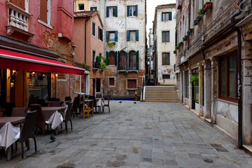 Old street with tables of restaurant in Venice, Italy. Architecture and landmark of Venice. Cozy cityscape of Venice. - 790256968
