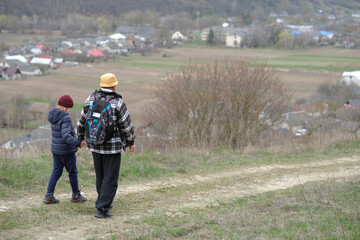 Active senior and his grandson walking the path holding hands. Happy family active outdoor. Active...