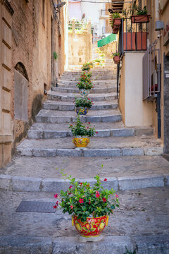 Colour flower pots lining the steps in the old town of Cefalu, Sicily