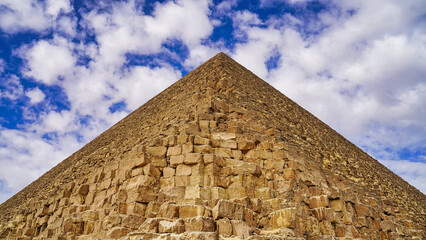 Perfectly symmetrical view of the Great Pyramid of Khufu with its yellow limestone blocks against a...
