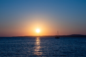 Naklejka na ściany i meble Yacht at anchor at Calaforte, Sant Antioco, Sardinia, at sunset