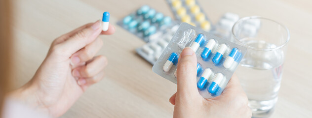 Sick ill asian young woman, girl hand taking tablet pill capsule out from blister pack, painkiller...