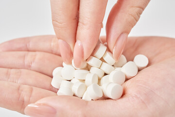 手のひらに乗せられたたくさんの錠剤
