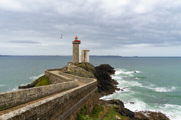 Une mouette survole gracieusement le phare du Petit Minou, ajoutant une touche de vie à la scène emblématique de l'entrée du goulet de Brest, dans la Mer d'Iroise, en Finistère. © Laurent