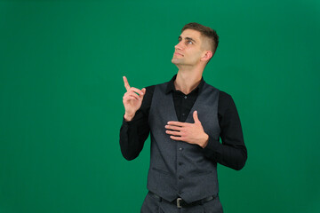 emotions of a handsome man guy on a green background chromakey close-up dark hair young man. young...